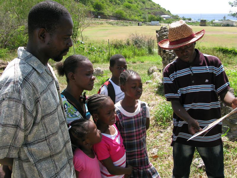 MSS 4th-former Ja-Moi Phillips guiding a family through the Little Bay Plantation sugar works during a site open house (photo by Jessica MacLean)