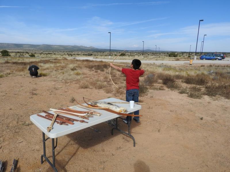 Young boy tries bow-and-arrow with animal targets