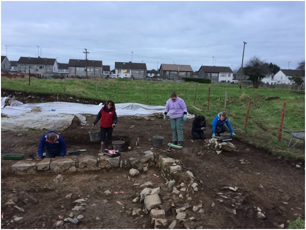 Students working in Cutting 6. The low wall delineates the remains of our chapter house.