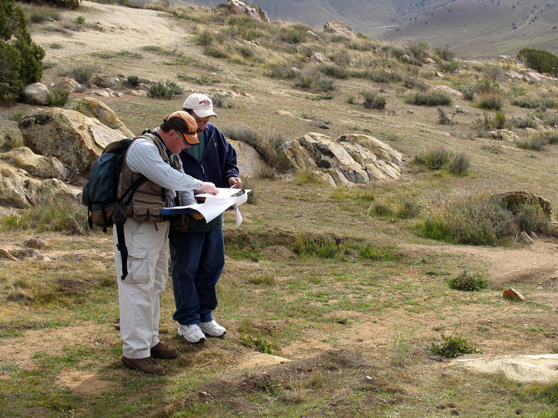 Two site stewards write their observations on a CASSP site visit form at a prehistoric site in the Sierras.