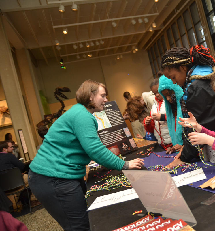 An AIA volunteer teaches fair attendees about Inca quipu. (Photo credit: Khaaliq Thomas)