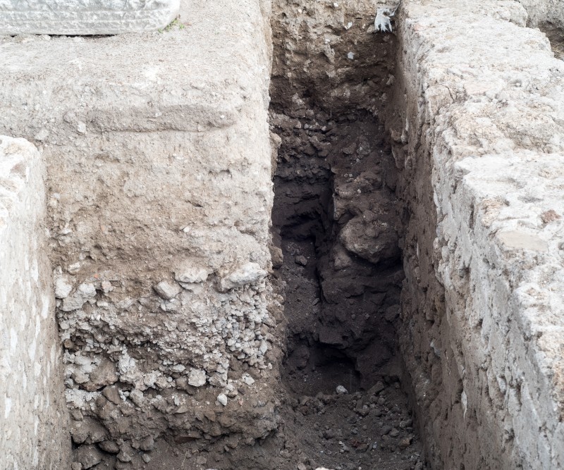 Figure 1: View of the N-S concrete wall incorporated into the foundation of the E portico of the Sanctuary of Venus. To the left: foundation of the Flavian portico. (Author: Dan Diffendale, VPP).