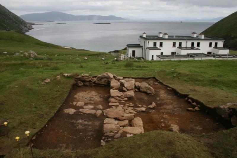 The interior of the building in Trench 2, showing the fully exposed floor surface and the cross drain leading through the doorway and out into a shallow drainage channel running off down the hill