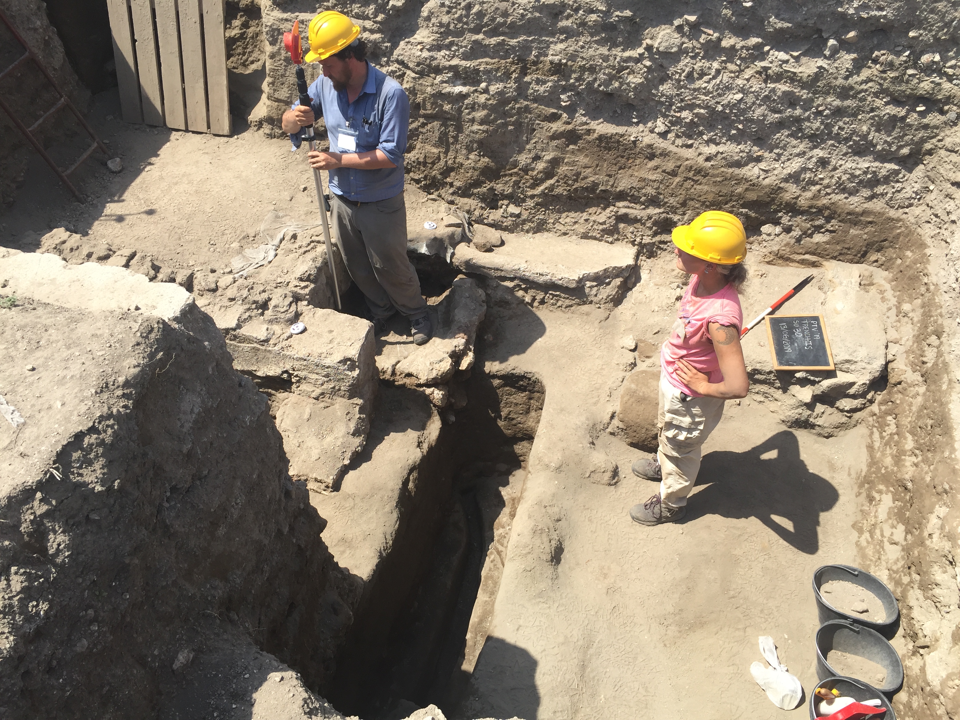 Figure 3: Surveying the feeding channel identified below the floor levels of the room occupied by the round cistern and cocciopesto basin.